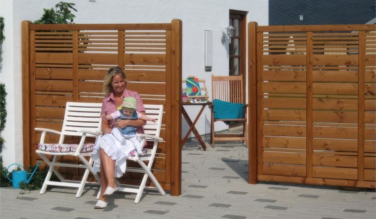 Ihre Sichtschutzblenden Silence Teak erhalten Sie in verschiedenen Ausführungen. Der Zaun ist ein robuster und langlebiger Gartenfreund aus farbgrundiertem Kiefer- oder Fichtenholz.